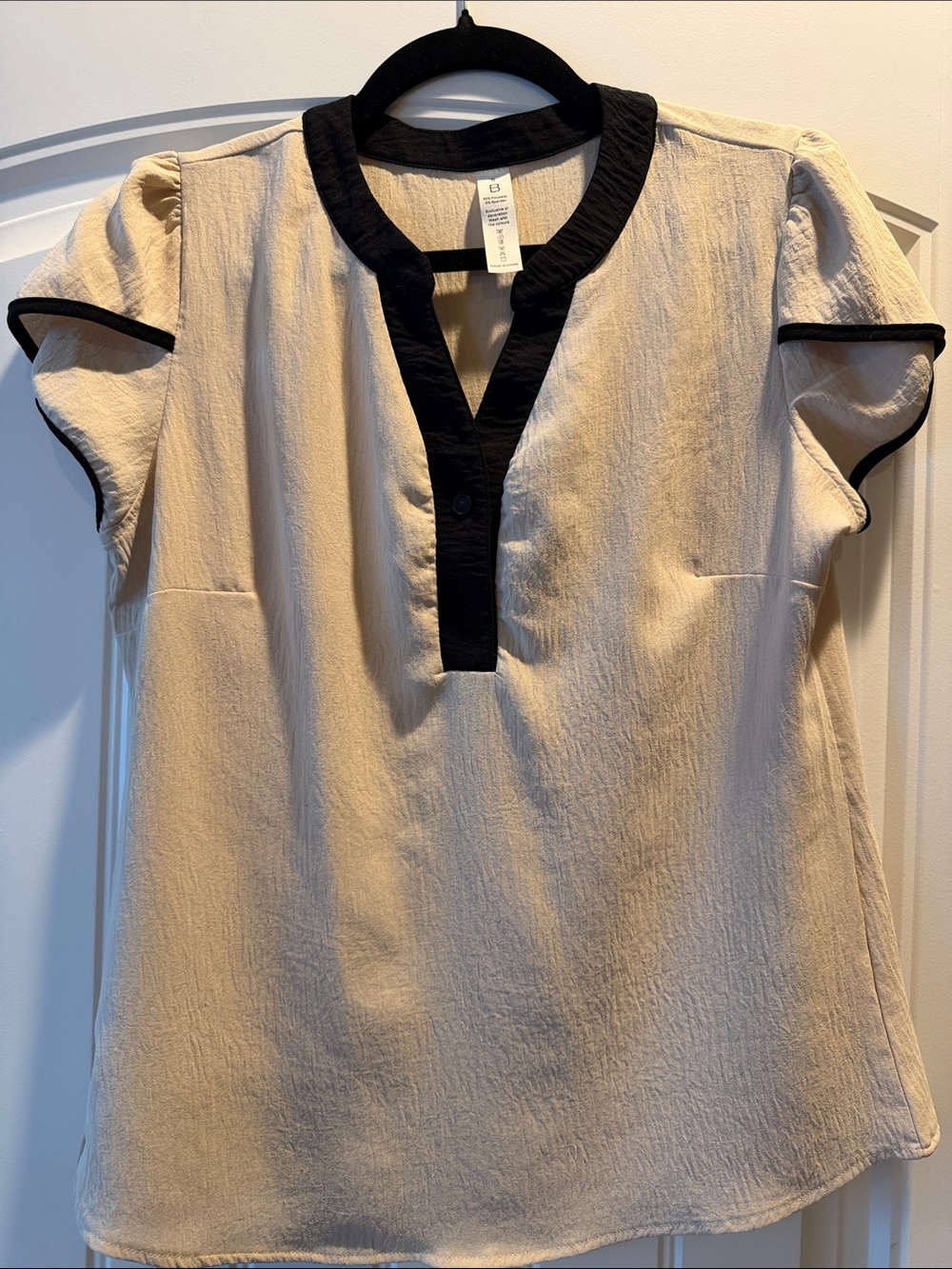 B - women’s khaki sleeveless blouse.